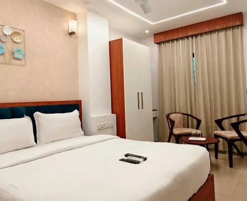 Deluxe Double room at Hotel Royal Luxe with a teal headboard and wooden wardrobe