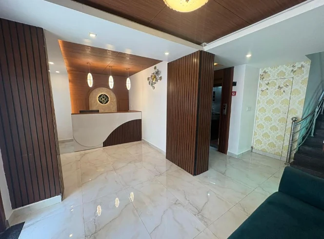 Reception desk at Hotel Royal Luxe with a timber ceiling and teal sofa