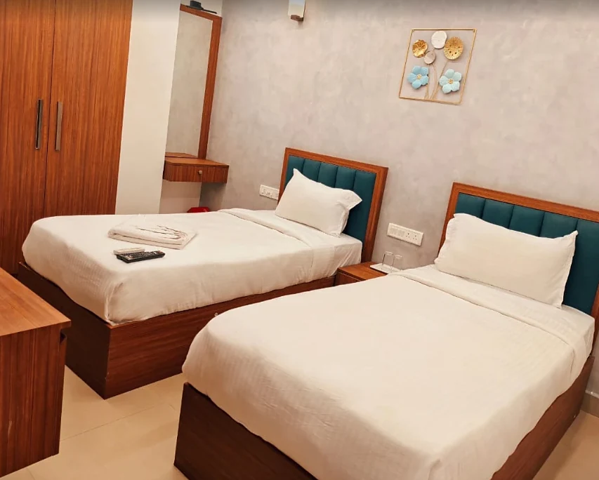 Twin Bed room at Hotel Royal Luxe with teal headboards and a work desk